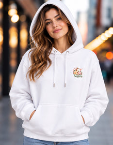 Woman wearing the white Let Them Have Tomorrow hoodie with the hood up and a small vegan emblem on the chest